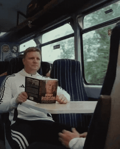 Man Reading Bobby Robson Book GIF
