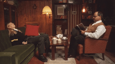 Man Reading Book Beside Woman On Couch GIF