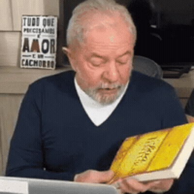 Man Reading Book In Front Of Laptop GIF