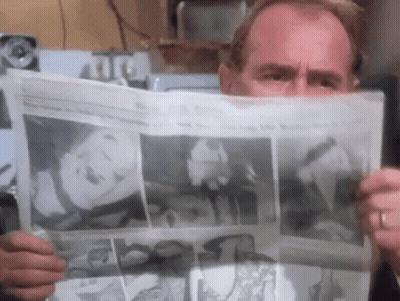 Man Reading Newspaper With Woman On Front GIF