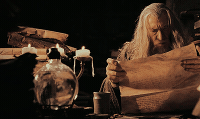 Man Reading Paper With Candles GIF