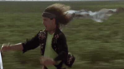 Man Riding Bicycle With Flying Scarf In Field GIF