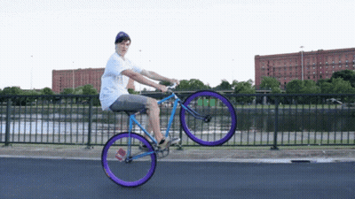 Man Riding Bicycle With Purple Wheel GIF