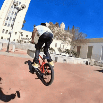 Man Riding Bike In Front Of Building GIF