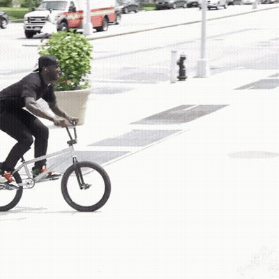 Man Riding Bike On Sidewalk Next To Staircase GIF