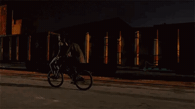Man Riding Bike On Street At Night GIF