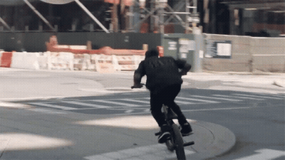 Man Riding Bike Past One Way Sign GIF