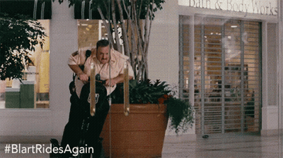 Man Riding Exercise Bike In Front Of Bath & Body Works GIF