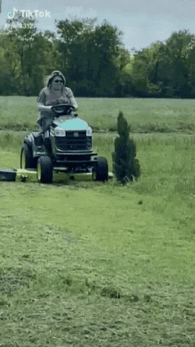 Man Riding Lawn Mower Through Field GIF