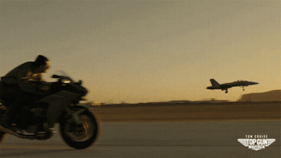 Hombre montando moto frente a avión de Top Gun Maverick GIF