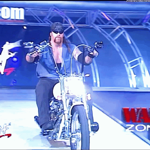 Man Riding Motorcycle In Front Of W.O.P Sign GIF