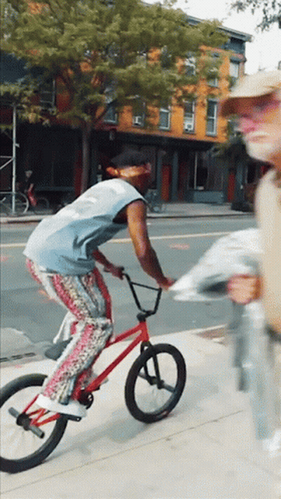 Man Riding Red Bike Down Street GIF
