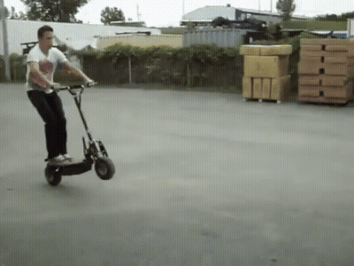 Man Riding Scooter In Parking Lot GIF