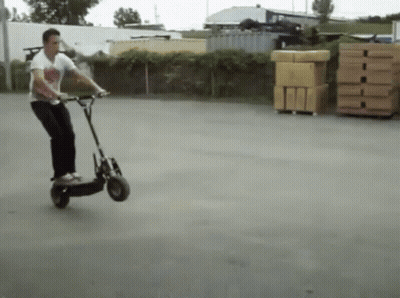 Man Riding Scooter In Parking Lot GIF