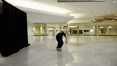 Man Riding Skateboard in Large Room