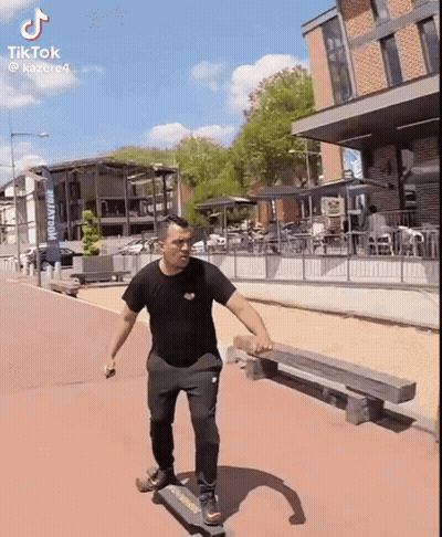 Man Riding Skateboard Past Brewery Sign GIF