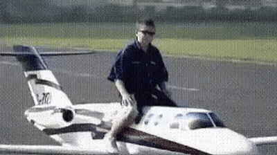 Man Riding Small Airplane Wing GIF