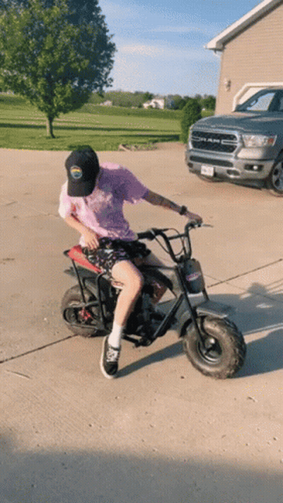 Man Riding Small Motorcycle Beside Ram Truck GIF