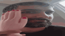 Man Rubbing Face Using Rubber Hand Toy GIF