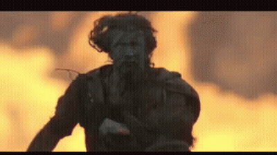 Man Running In Front Of Fire With Gun GIF