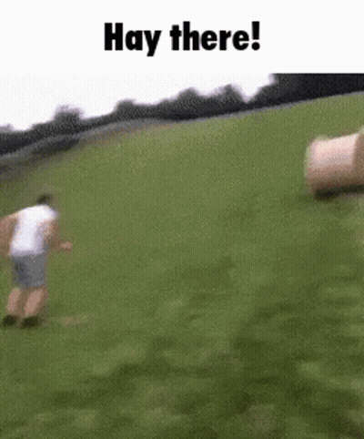 Man Running In Grassy Field With Hay Bales GIF
