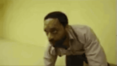 Man Running In Hallway With Picture Of Man And Letter T GIF