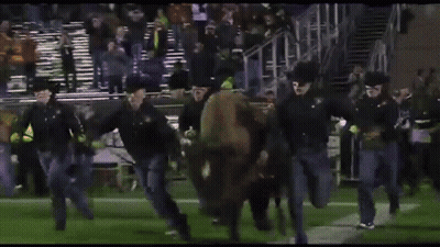 Man Running On Football Field Holding G Banner GIF