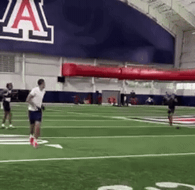 Man Running On Football Field Past Sign Saying A GIF