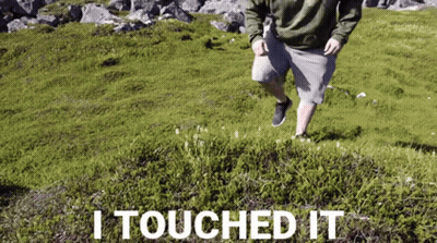Man Running On Grassy Hill Saying I Touched It GIF