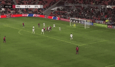 Man Running On Soccer Field In Front Of Nacho Nacho Sign GIF
