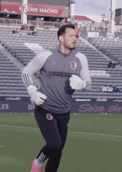 Man Running On Soccer Field In Front Of Nacho Nacho Sign GIF