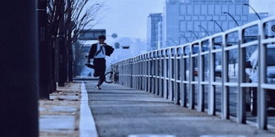 Man Running With Bicycle On Sidewalk GIF