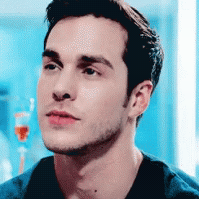 Man's Face Close Up In Front Of Blue Wall GIF