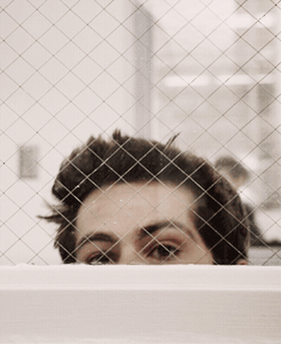 Man's Face Through Wire Fence GIF