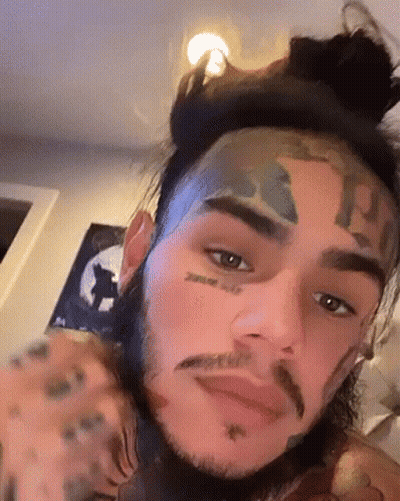 Man's Face With Bun And Tattoos GIF