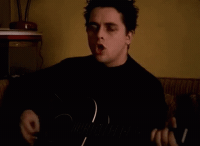 Man Singing And Playing Guitar In Dark Room GIF