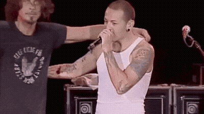 Man Singing Into Mic With Arm Around GIF