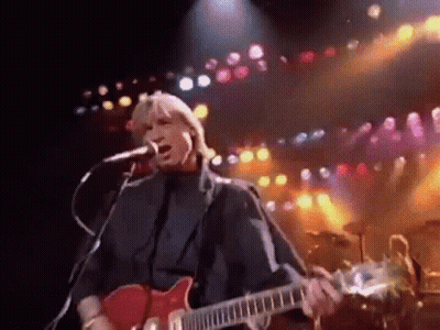 Man Singing Into Microphone And Playing Guitar On Stage GIF