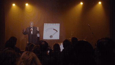 Man Singing Into Microphone At Volume Sign GIF