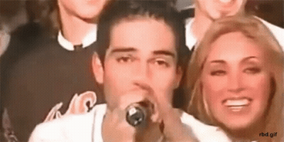 Man Singing Into Microphone Beside Woman GIF