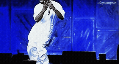 Man Singing Into Microphone Dancing On Stage GIF