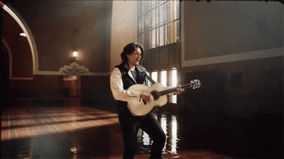 Man Singing Into Microphone Holding Guitar GIF
