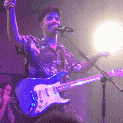 Man Singing Into Microphone Holding Guitar GIF