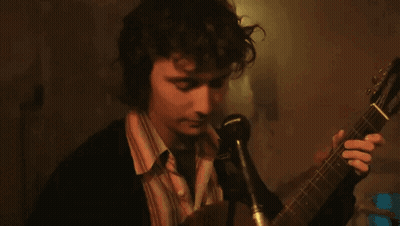 Man Singing Into Microphone Holding Guitar GIF