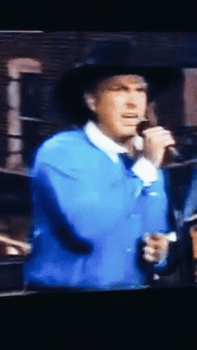 Man Singing Into Microphone In Blue Jacket GIF