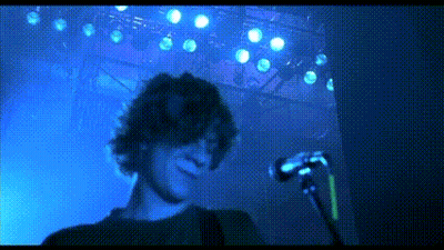 Man Singing Into Microphone In Blue Light GIF