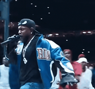 Man Singing Into Microphone In Blue Ria Jacket GIF