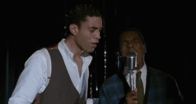 Man Singing Into Microphone In Dark Room GIF
