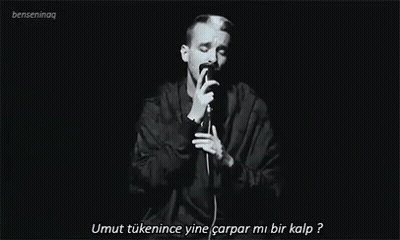 Man Singing Into Microphone In Dark GIF