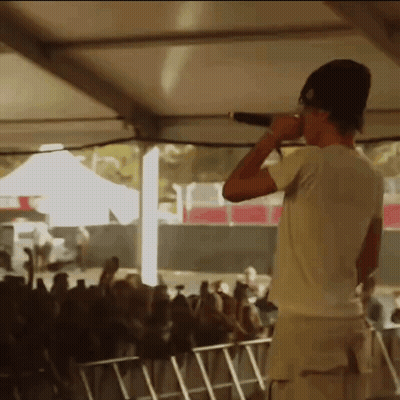 Man Singing Into Microphone In Front Of Crowd GIF